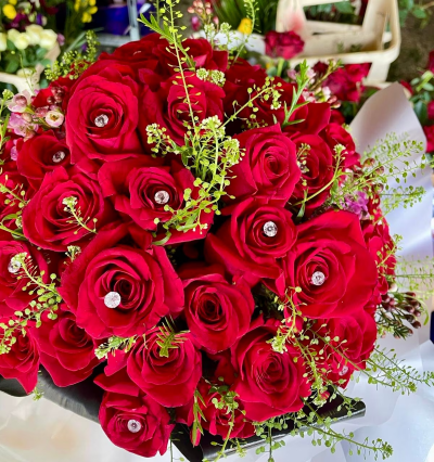 Virginia's Super Stunning 50 Luxury Red Roses - An extravagant gesture of love, this stunning bouquet of 50 velvety, long stemmed luxury red roses is a real show stopper.
Love is in the air, and what better way to spoil your Valentine than with the ultimate romantic gesture of sending 50 red roses? Our 50 Red Rose Handtied is created using premium large red roses such as Freedom or Naomi varieties - chosen for their beauty, high petal count and velvet ruby red colour. We add gorgeous green foliage for texture and diamonte pins before carefully wrapping in pretty kraft paper and tying with ribbon.