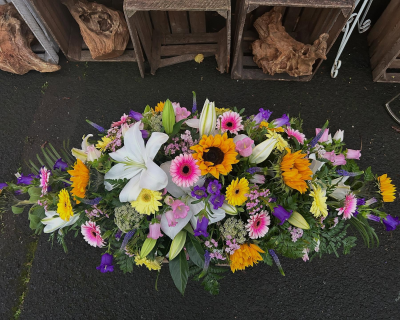 Vibrant Spray - A bright and uplifting casket spray filled with cheerful, colourful tones.